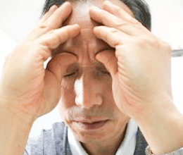 指を額に当てている画像