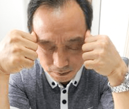 こめかみを指で押す画像